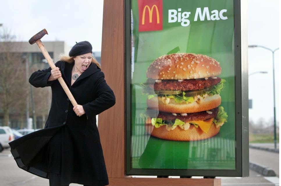 Larissa met een hamer bij een Big Mac reclamebord